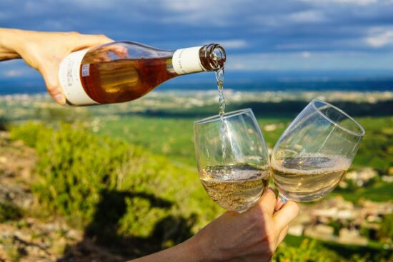 person som häller upp vin i glas