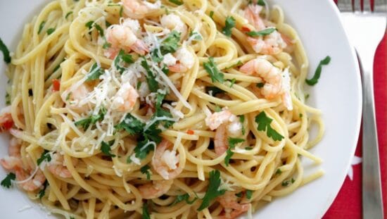 Default A creamy plate of pasta and shrimps with a garnish of 2